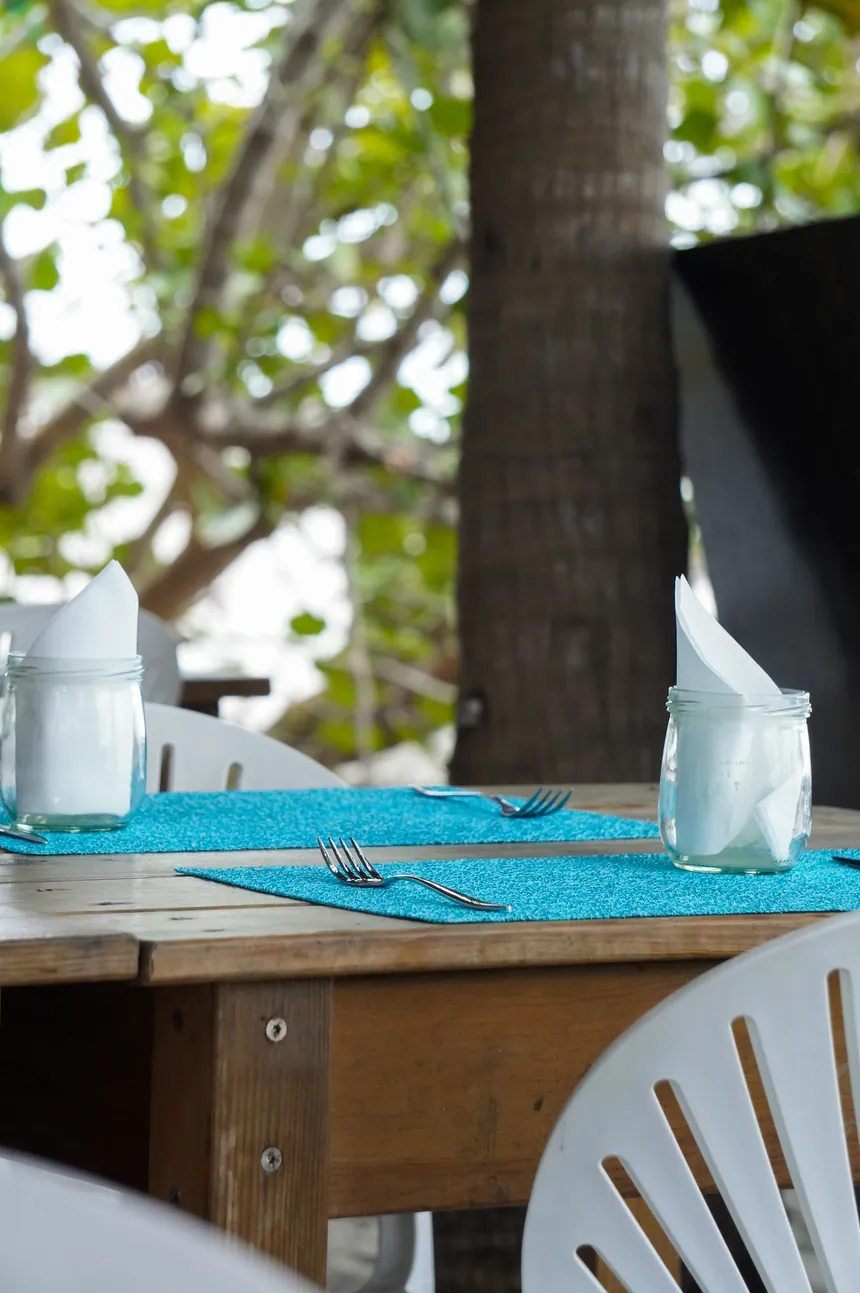 Table dressée avec sets turquoise à l'ombre des raisiniers